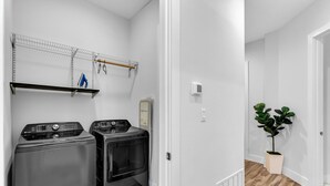 A laundry area with two washing machines and a drying rack. - NEW Modern 1BR in Oak Lawn Dallas With Free Parking + Complimentary EV Charger (Dallas)