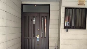 A clean, modern entrance with a dark wooden door, a metal kick plate, and a concrete floor. - Guest house Chiharu" 6 rooms, 12 people MAX ・ 4 minutes from JR Teradacho station, near Tennoji USJ direct access hot spring (ikunonishi, ikuno ward, Osaka city)