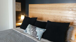A bed with a wooden headboard, multiple pillows, and a bedside lamp. - Lofty Haven - High/ Harbour Views of Narrows & Signal Hill/ Steps to Downtown (St. John's)