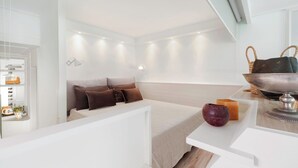 Ett modernt hotellrum med en säng, ett sängbord och ett stort fönster.