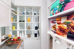 A modern kitchen with white cabinetry, a built-in pantry, and a variety of kitchen items. - Casa Amica – Central Apartment in Sorrento (Sorrento)