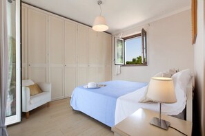 A bedroom with a bed, bedside table, lamp, and a wardrobe. - Villa Lume - Private Villa With Pool (Sant'Agata sui Due Golfi)