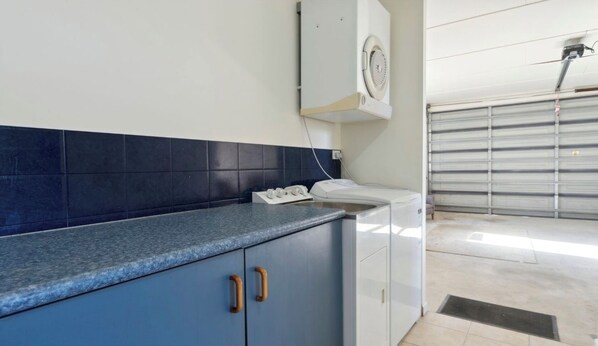 A kitchen with blue cabinets, a white countertop, and a built-in oven.