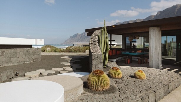 Woestijnlandschap met een terras, een cactus, een stenen muur en uitzicht op de oceaan.