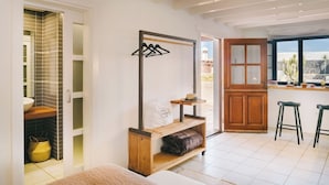 A modern kitchen with a wooden countertop, a hanging rack, and a view of the outdoors. - Canaryislandshost I Esencia III (Urbanización Famara)