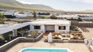 A rooftop pool area with a pool, lounge chairs, and cacti. - Canaryislandshost I Esencia III (Urbanización Famara)