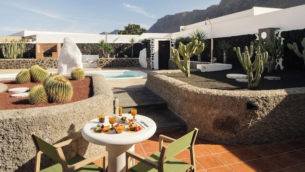 A rooftop garden with a pool, cacti, and a table set for a meal. - Canaryislandshost I Esencia III (Urbanización Famara)