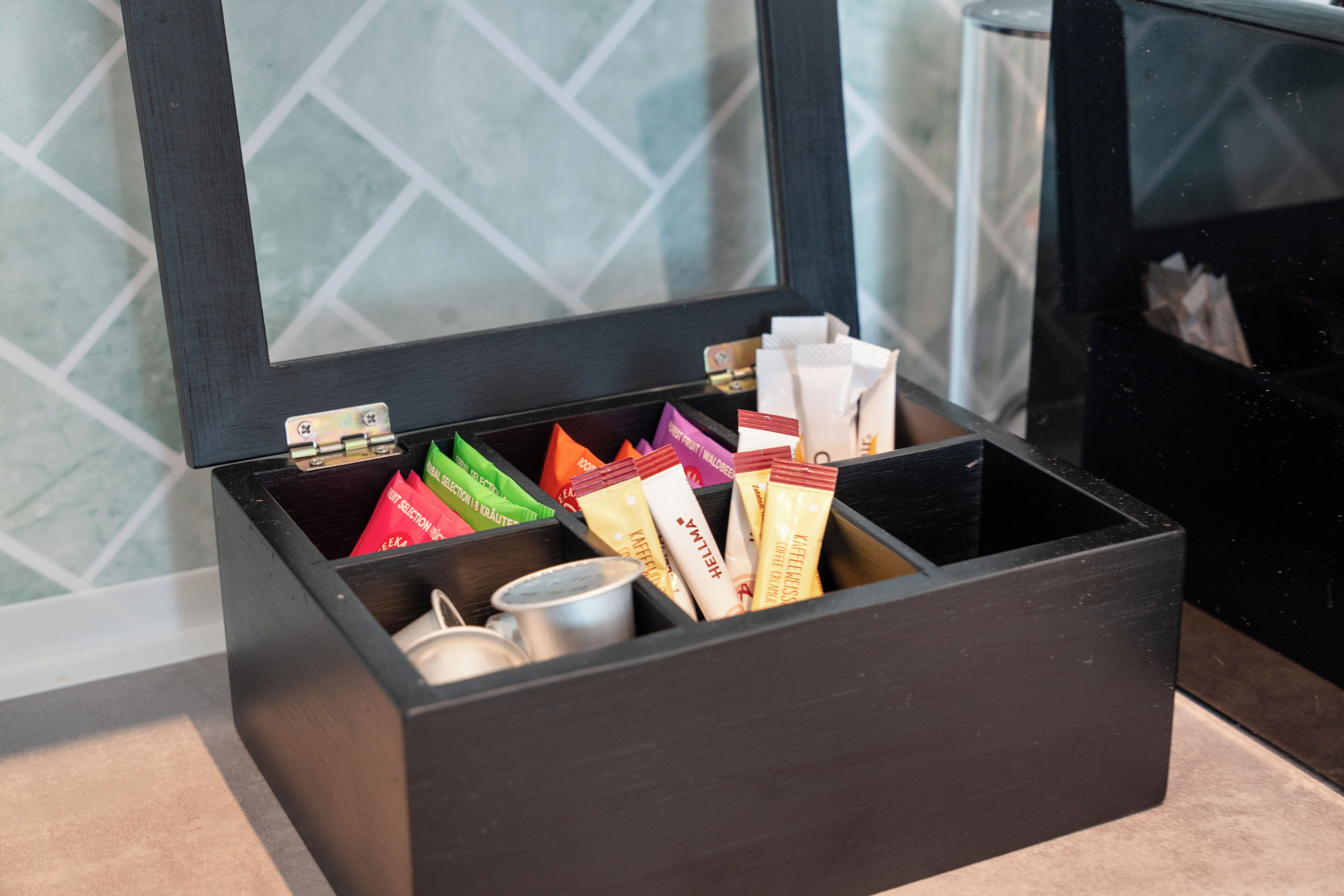 A black storage box with compartments containing various items.