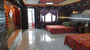 Una habitació amb un llit, escriptori i armari. Hi ha una finestra amb cortines i una porta que dóna a l'exterior.