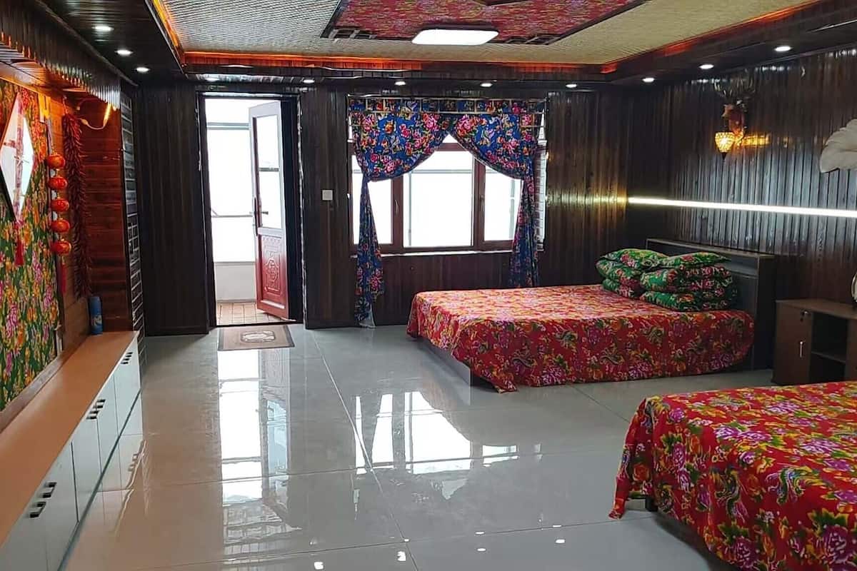 A room with a bed, a desk, and a wardrobe. There is a window with curtains and a door leading outside.