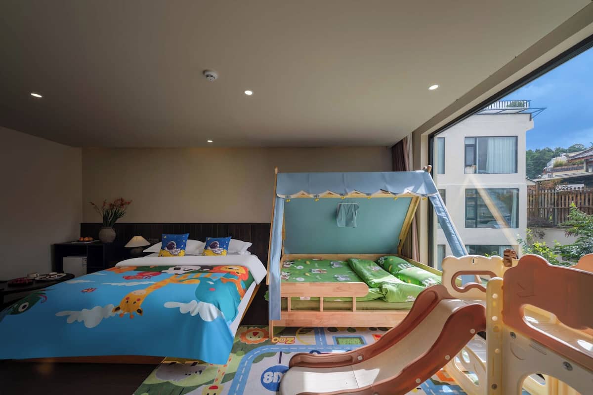 Ein Kinderzimmer mit Etagenbetten, einer Rutsche und einem Spielbereich.