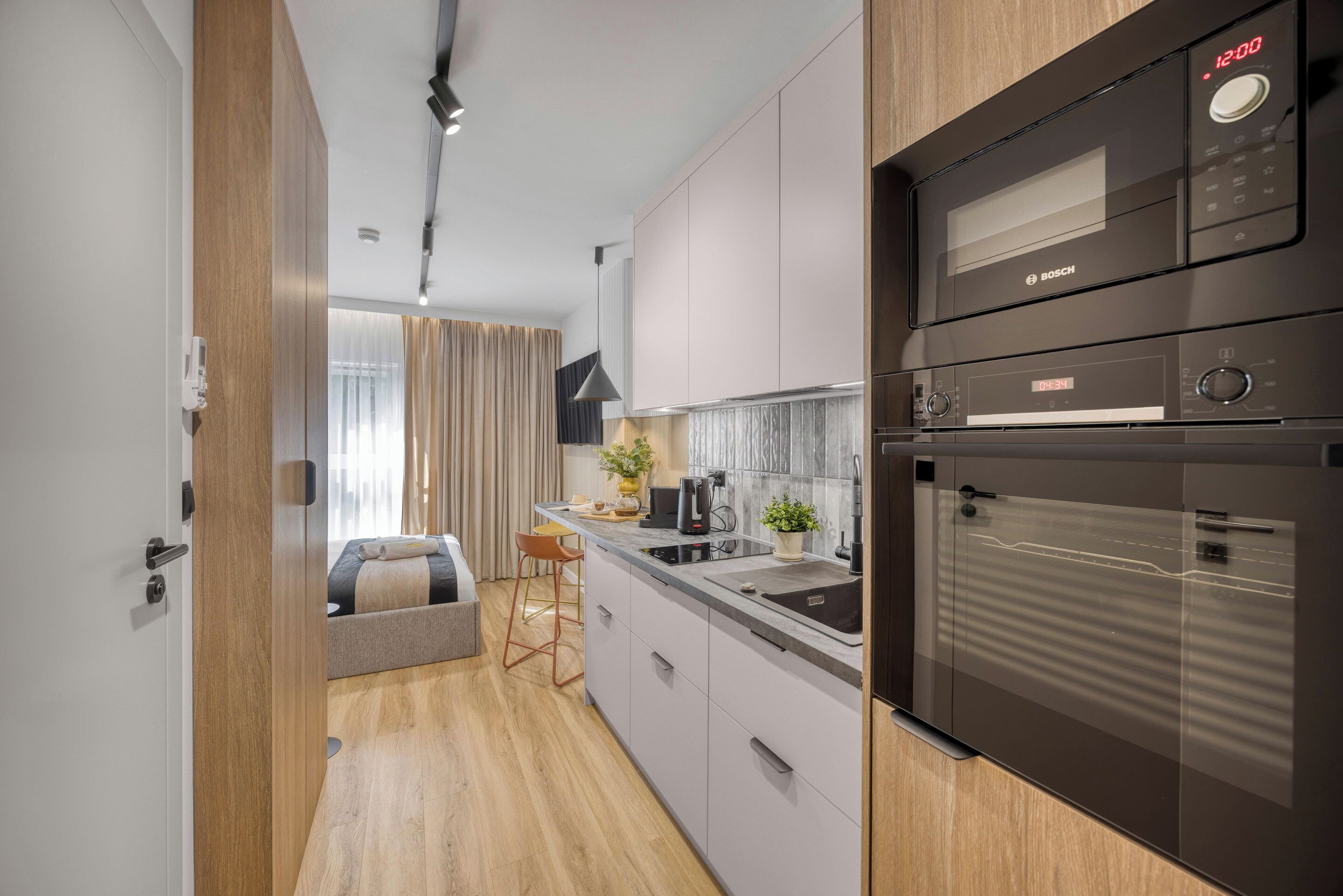 Een moderne keuken met een Bosch magnetron, oven en koffiezetapparaat.
