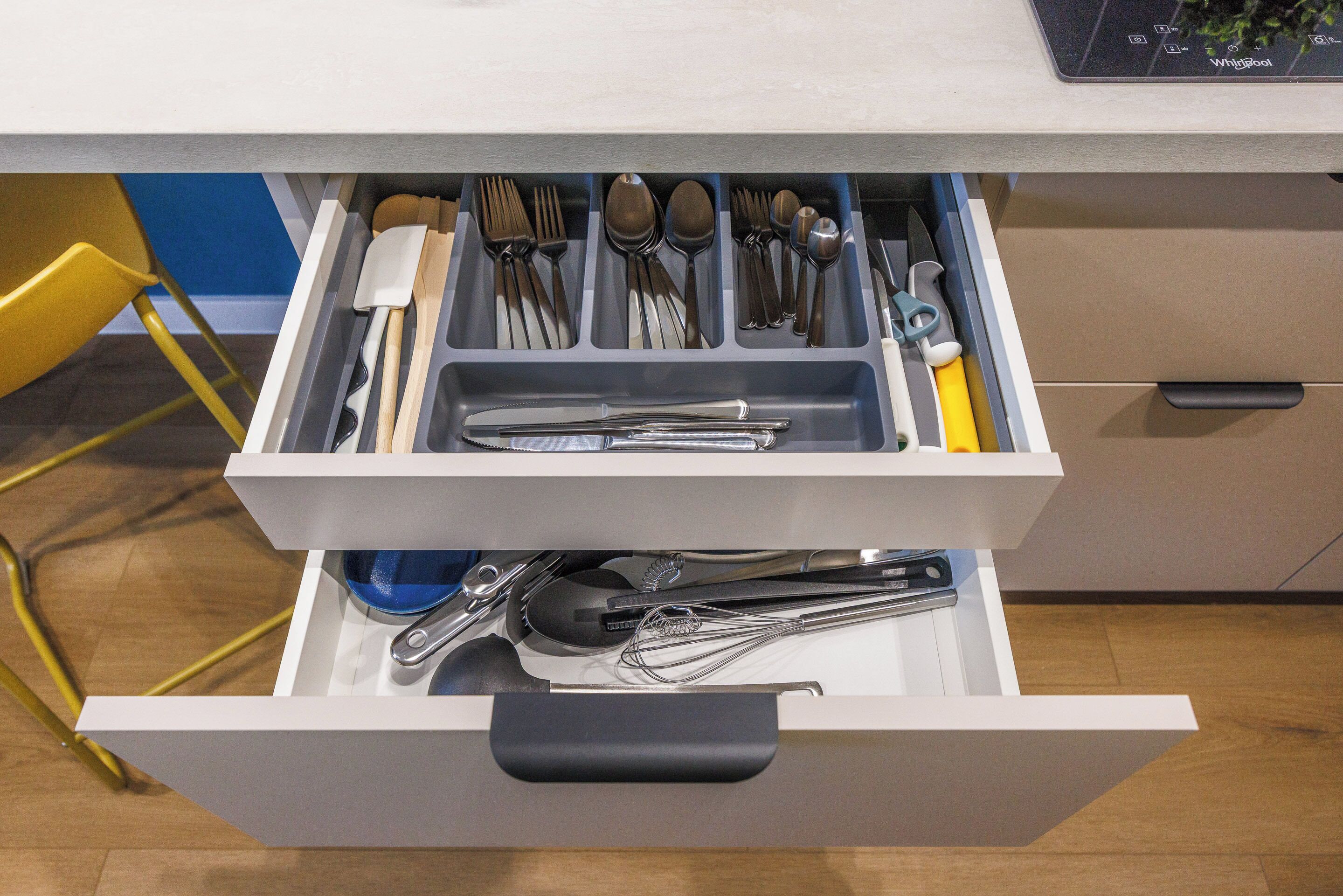Un cajón con utensilios de cocina, como cucharas, tenedores y cuchillos.