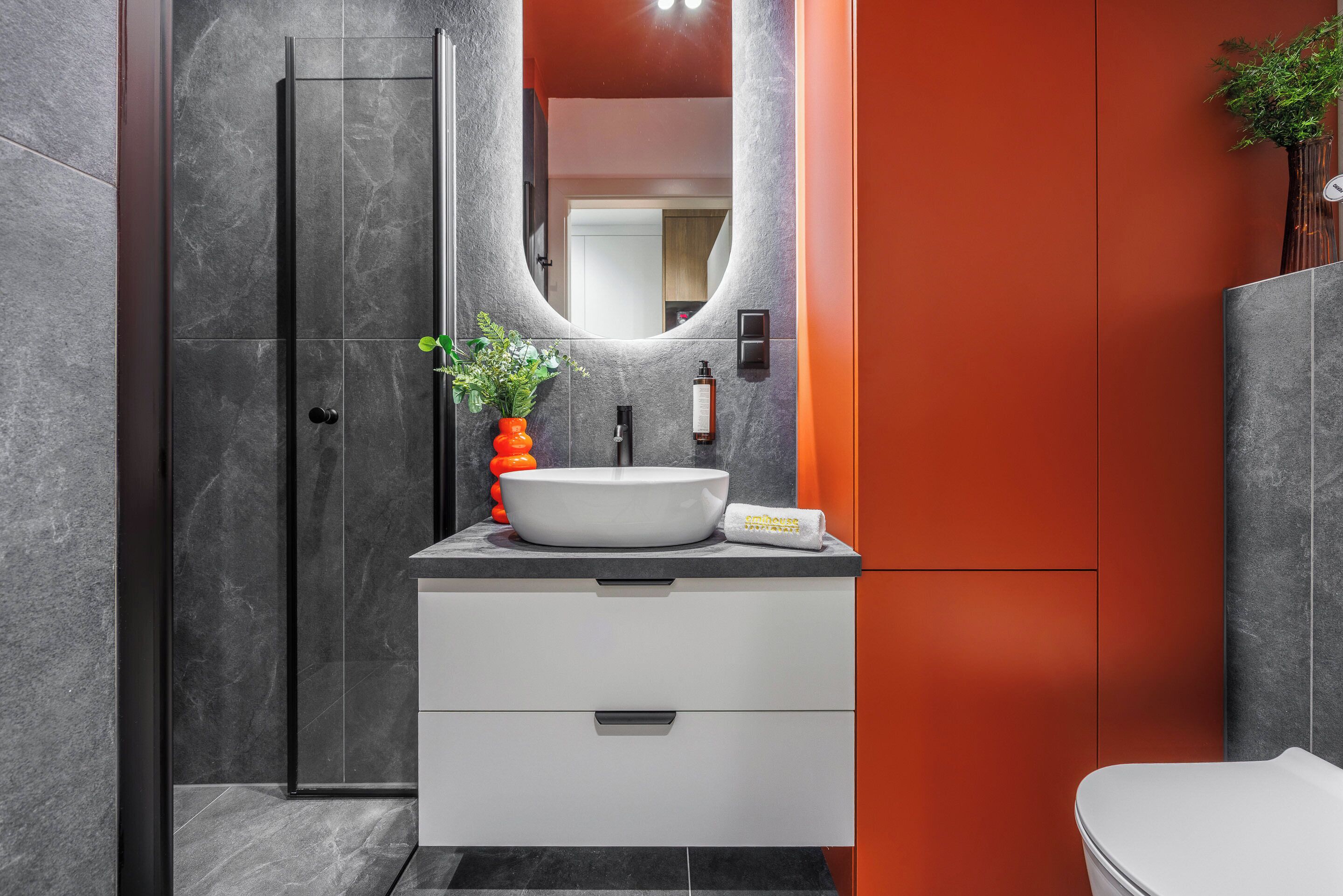 A modern bathroom with a white sink, a mirror, and a shower.