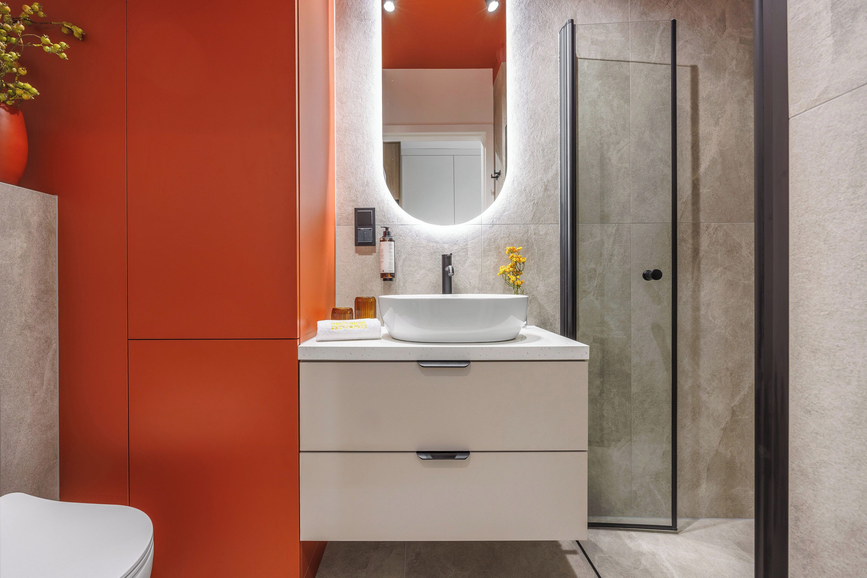 A modern bathroom with a white sink, a mirror, and a glass shower enclosure.