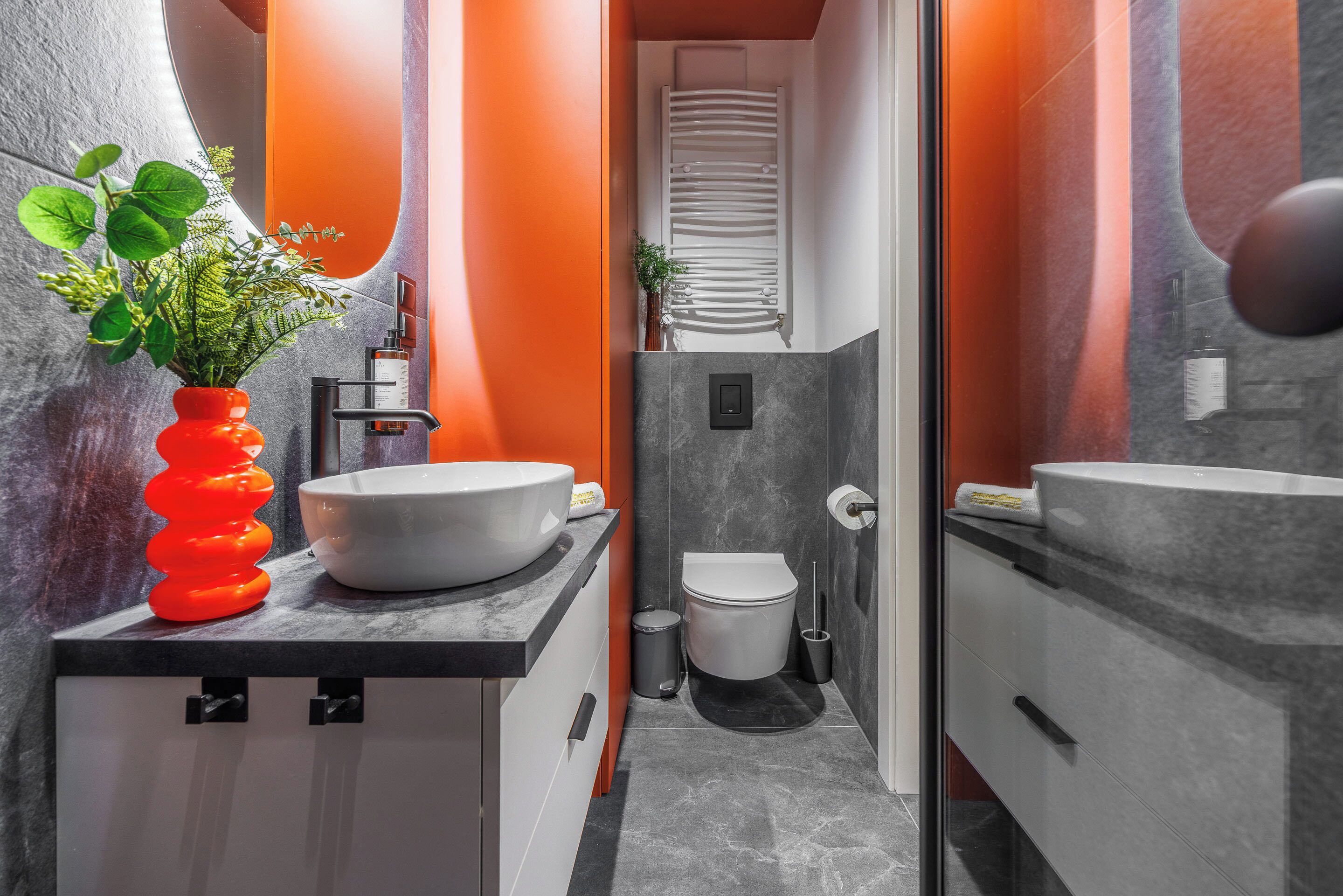 Un baño con lavamanos blanco, inodoro y espejo.