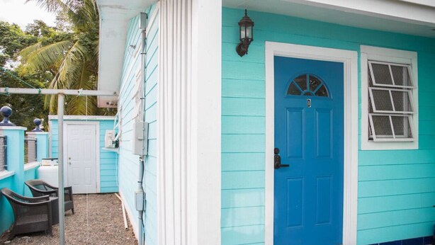 A house with a blue door and a window with a white frame. - Cozy Retreat | 5 mins to Beach & Downtown (Nassau)