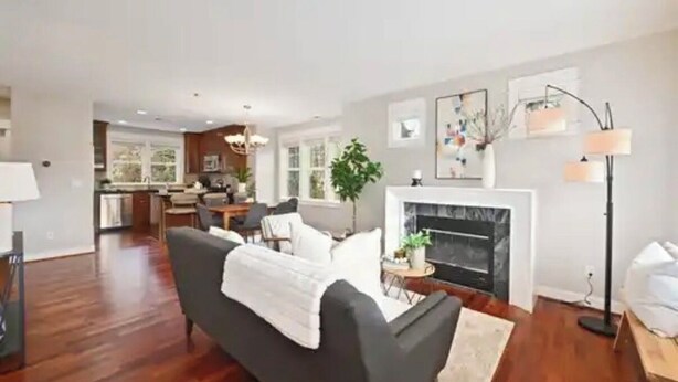 A spacious living room with a fireplace, a dining area, and a kitchen in the background. - A marvelous 3-bedroom townhome in lovely Seattle  near children’s hospital (Seattle)