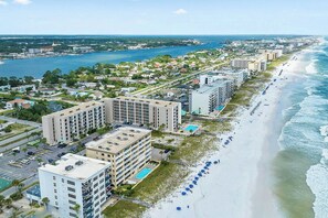 A coastal hotel with multiple buildings, a beach with umbrellas, and a view of the ocean. - Emerald Isle 712 •  Amazing 2-Bedroom 2-Bath - Beachfront Top Floor, Ocean View- Free Bch Srvc (Fort Walton Beach)