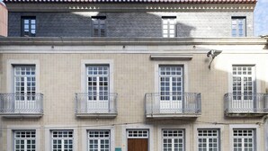 Ein zweistöckiges Gebäude mit einem Ziegeldach, zahlreichen Fenstern und Balkonen.
