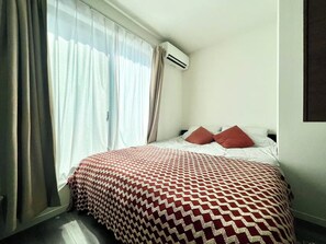 A hotel room with a bed, curtains, an air conditioning unit, and a window. - Fukusuke HARUKA Tsuruhashi 5mins walk JR Loop/Namba/USJ/ (tsuruhashi, ikuno ward, Osaka city)