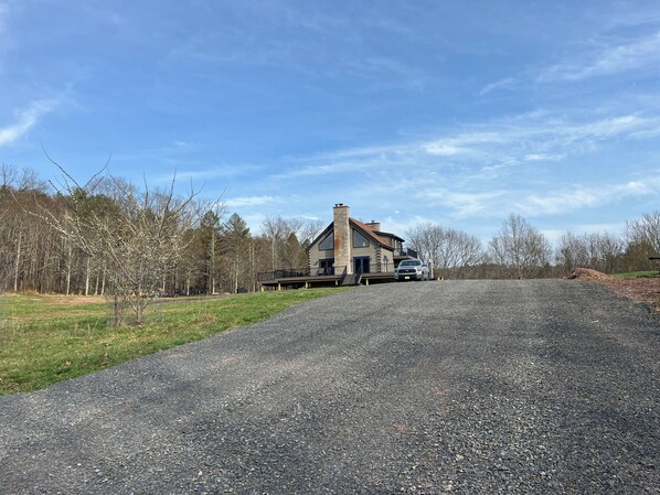 A two-story house with a gravel driveway and a truck parked in front. - Remote Cabin near Knoebel’s (Catawissa)