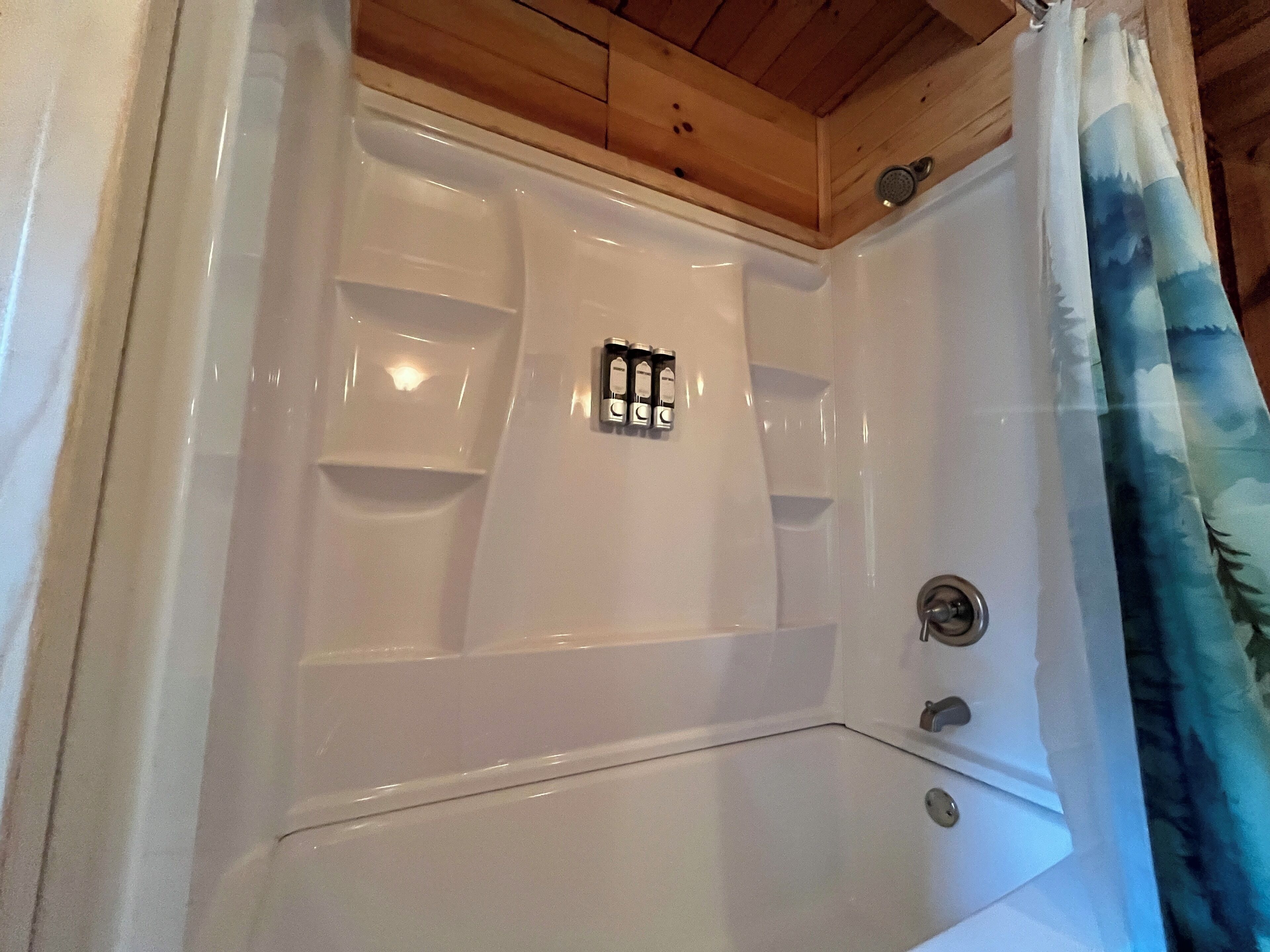 A hot tub with a wooden ceiling and a showerhead.