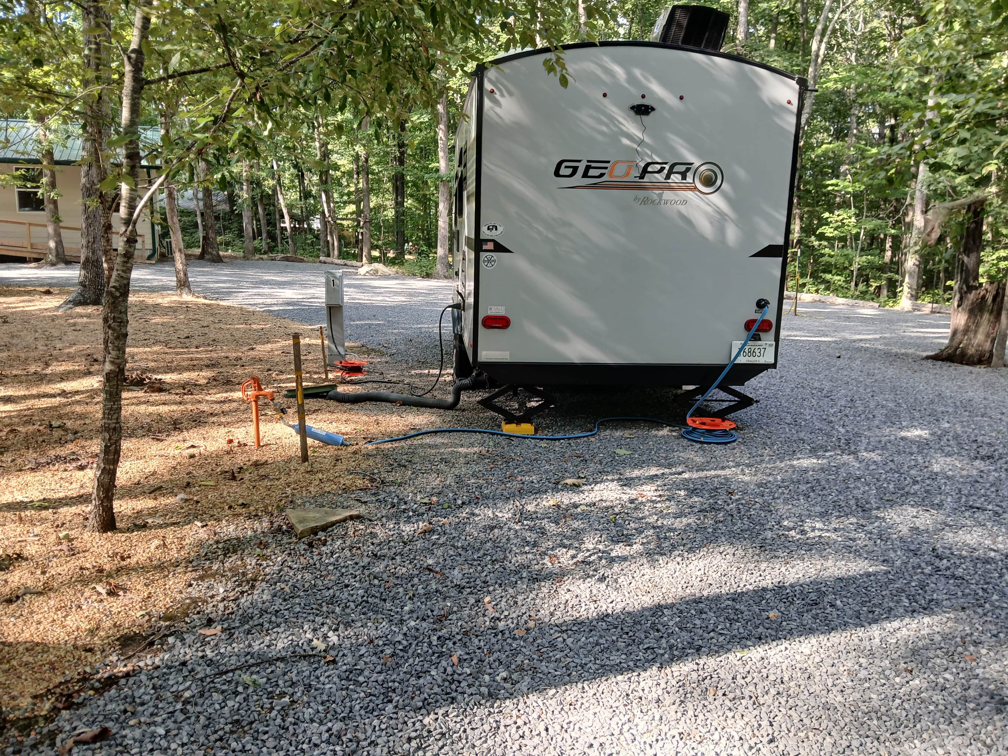 A white RV with 'GEOPRO' branding parked on gravel.
