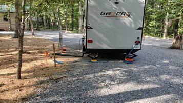 A white RV with 'GEOPRO' branding parked on gravel.