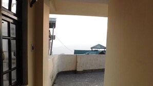 A narrow corridor leading to a rooftop terrace with a view of the sky. - OS HOTEL HIDDEN FLOWER (Gangtok)
