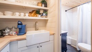 Una cucina moderna con lavello, macchina del caffè e pensili.