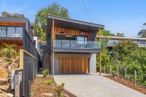 Ein modernes, zweistöckiges Haus mit Balkon, Garage und gepflegtem Garten.