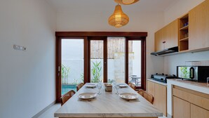 Una cucina moderna con una grande isola, mobili in legno e vista sul mare.