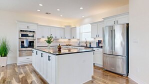 A modern kitchen with white cabinetry, stainless steel appliances, and a central island. - KD694 Private Heated Pool, Ocean Views (Port Aransas)