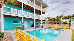 A two-story building with a pool, yellow chairs, and a white fence. - KD694 Private Heated Pool, Ocean Views (Port Aransas)