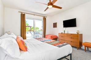 A bedroom with a bed, a dresser, a television, and a ceiling fan. - Indigo Sky Oasis: Pool, Hot Tub, Near Joshua Tree (Yucca Valley)