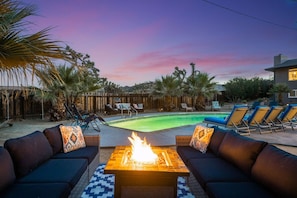 A pool area with lounge chairs and a fire pit. - Indigo Sky Oasis: Pool, Hot Tub, Near Joshua Tree (Yucca Valley)