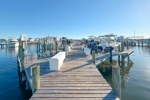 A wooden pier leading to a marina with boats docked on both sides. - Waterfront Condo w/ Boat Slip, Lift, Pools & Cove Views | BEACHBALL PROPERTIES (Orange Beach)