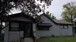 A residential house with a front porch, a mailbox, and a small garden with flowers.
