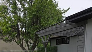 An outdoor patio area with a fire pit, outdoor furniture, and a pergola.