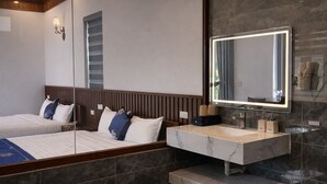 A modern hotel room with a large bed, a bathroom with a marble vanity, and a large mirror. - Senna Garden HomeStay (Hoa Lu)