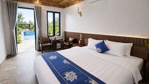 A hotel room with a large bed, a desk, two chairs, a view of a swimming pool, and a wooden ceiling. - Senna Garden HomeStay (Hoa Lu)