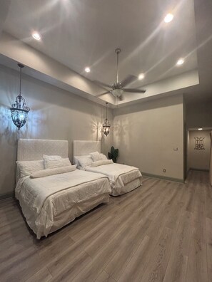 A bedroom with two beds, a ceiling fan, recessed lighting, and a chandelier. - The Best of New Orleans: Lakefront Area Luxury Meets City Access! (New Orleans)