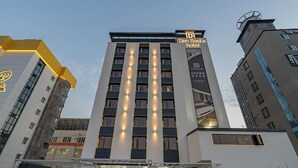A modern hotel building with a prominent 'Den Besta hotel' sign, multiple floors, and a central entrance with steps. - Denbasta Hotel Busan Jeonggwan (Busan)