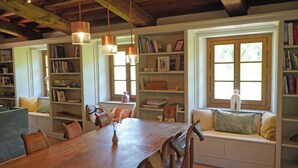 Un coin repas accueillant, avec une table et des chaises en bois, entouré d’étagères et agrémenté d’une fenêtre offrant une vue agréable.