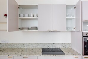 A kitchen with white cabinets, a granite countertop, and a black cutting board. - Blueground | Gros-Caillou, view, nr Eiffel Tower (Paris)