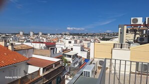 A cityscape with multiple buildings, some with flat roofs and others with sloped roofs. - Superior guest room with private bathroom (Sitges)