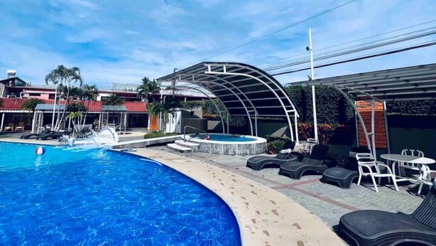 A swimming pool with lounge chairs and a covered seating area. - 100m from the beach - Cozy and with 24/7 security (Jacó)