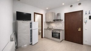 Una cucina compatta con frigorifero, forno e microonde.