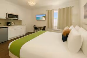 A hotel room with a bed, a desk, a microwave, and a window with curtains. - Charming Studio at Miami Beach near sand (Miami Beach)